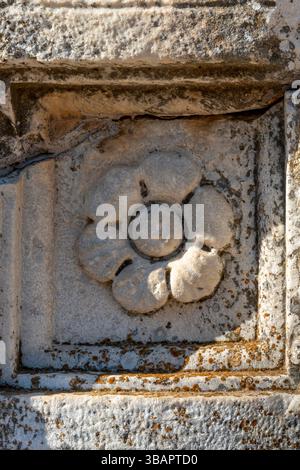 Antico rilievo in pietra floreale di Efeso caratterizzato da una rosetta circolare circondata da petali stilizzati scolpiti in marmo. Foto Stock