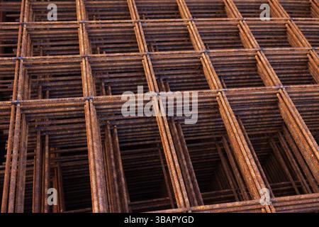Il rinforzo in acciaio saldato, arrugginito è disposto uno sull'altro. Foto Stock