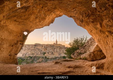 Matera, Italia come si vede dall'interno di un'antica grotta al crepuscolo. Foto Stock