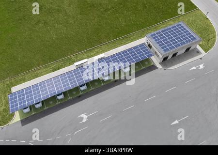 Stazione di ricarica per auto elettriche che assorbe energia dai pannelli solari. Vista aerea del tettuccio solare. Foto Stock