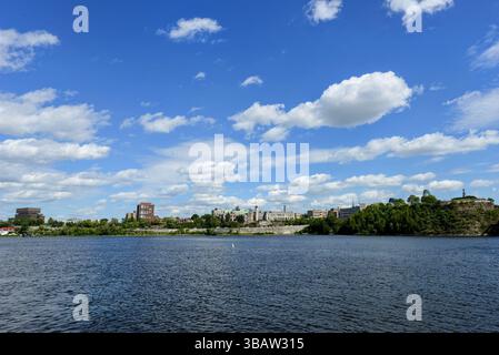 Skyline della città di Gatineau, Quebec, vista dall'altra parte del fiume Ottawa in una giornata di sole con nuvole sparse e cielo azzurro. Foto Stock