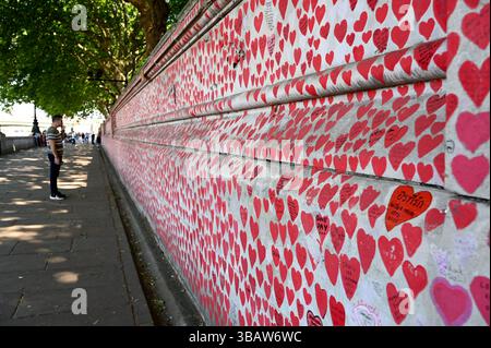 Il sole splende oggi su Westminster , le strade erano piene di turisti e visitatori molti che visitavano Londra per vedere il Big Ben altri selfie hanno visitato il Covid Memorial Wall per ricordare rendere omaggio dire una preghiera o ricordare quando il mondo intero ha chiuso con Covid . Un tempo che ha colpito tutti in modo imprevisto , nomi di molti dei nomi deceduti scritti sul muro come tributo . Foto Stock
