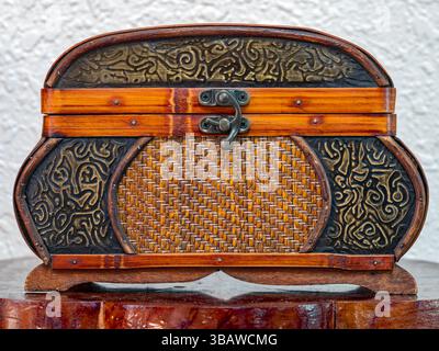 Primo piano di un petto di legno antico e rattan Foto Stock