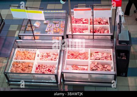 pezzi freschi di pollo, tacchino, vitello, maiale e manzo in contenitori nel frigorifero del supermercato Foto Stock