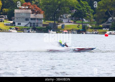 Barche a motore che corrono su un lago con grandi risvegli dietro di loro sotto forma di spruzzi. Le barche stanno accelerando sull'acqua Foto Stock