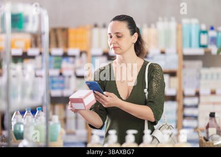 Donna di mezza età che esegue la scansione della confezione di pillole Foto Stock