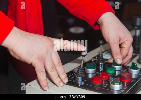 Il pannello di controllo della nave con joystick e pulsanti e le mani del navigatore sul pannello di controllo. Foto Stock