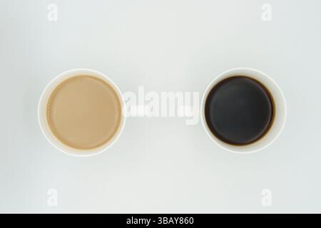due tazze di caffè in porcellana con americano e cappuccino su sfondo bianco Foto Stock
