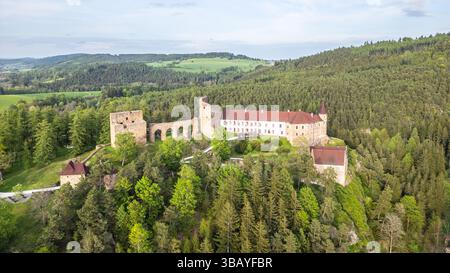 Il castello di Velhartice sorge maestosamente in cima a una collina, abbracciato da lussureggianti foreste verdi. Questo scatto aereo cattura la bellezza della struttura e del paesaggio in piena luce del giorno. Foto Stock