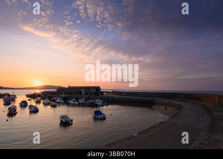 Lyme Regis, Dorset, Regno Unito. 14 maggio 2025. Meteo nel Regno Unito: Splendida alba sul porto presso la località balneare di Lyme Regis all'inizio di un'altra giornata calda e soleggiata. Crediti: Celia McMahon/Alamy Live News Foto Stock