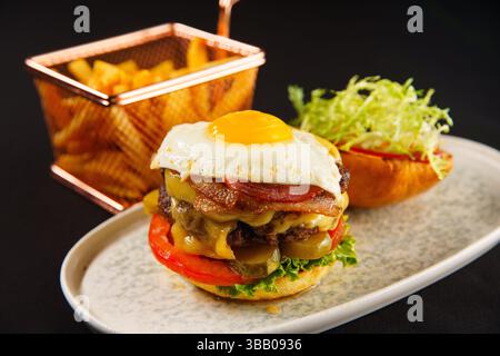 Ulan Bator, Mongolia. 6 maggio 2025. Doppio hamburger al formaggio appena cucinato e patatine fritte. Crediti: L.Enkh-Orgil. Foto Stock