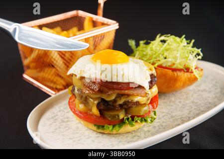 Ulan Bator, Mongolia. 6 maggio 2025. Doppio hamburger al formaggio appena cucinato e patatine fritte. Crediti: L.Enkh-Orgil. Foto Stock