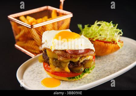 Ulan Bator, Mongolia. 6 maggio 2025. Doppio hamburger al formaggio appena cucinato e patatine fritte. Crediti: L.Enkh-Orgil. Foto Stock