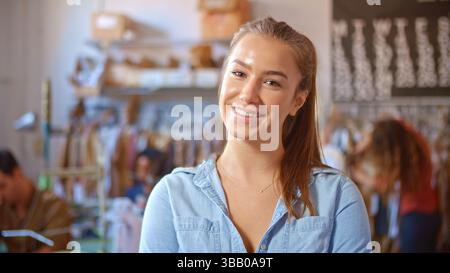 Ritratto di una donna sorridente proprietaria o lavoratrice di Fashion Design Studio che entra a fuoco Foto Stock