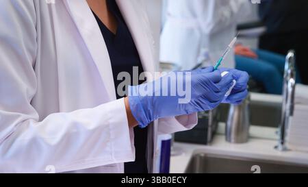 Primo piano della siringa in attesa di estetista o medico prima di iniettare il botox al paziente Foto Stock