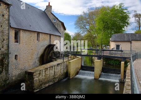Un mulino ad acqua sul fiume Aure nella città medievale di Bayeux, Calvados, Normandia, Francia, circondato da antiche case storiche Foto Stock
