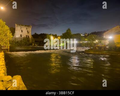 Il ponte visconti e il fiume mincio creano una suggestiva scena a borghetto, valeggio sul mincio, illuminata di notte Foto Stock