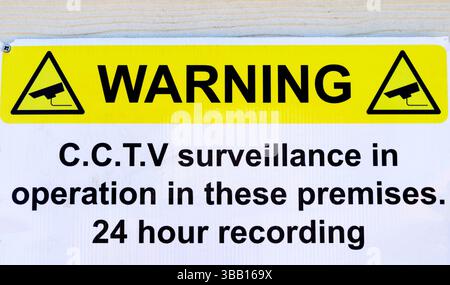 Telecamera di registrazione CCTV 24 ore in funzione segnale giallo su sfondo bianco Regno Unito Foto Stock