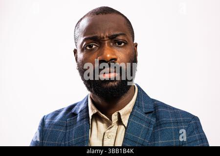 Primo piano ritratto di un uomo d'affari preoccupato e premuroso. L'uomo nero in costume da lavoro è in piedi e sta pensando. Foto Stock