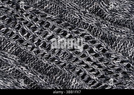 Sfondo di tessuto grigio denso con fili bianchi e neri. Parte di maglione lavorato a maglia. Foto Stock