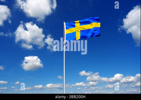 bandiera della svezia che fluttua nel cielo blu con le nuvole di cumulus Foto Stock