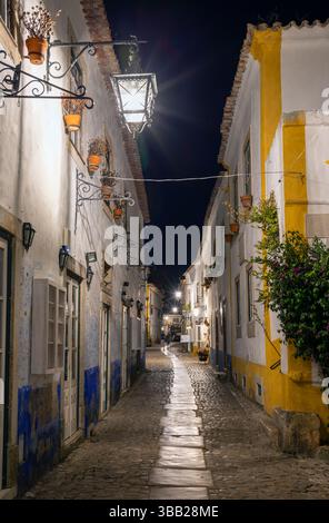 Portogallo, regione di Oeste, Óbidos, architettura tradizionale su Rua Direita all'interno della storica Cittadella murata di notte Foto Stock