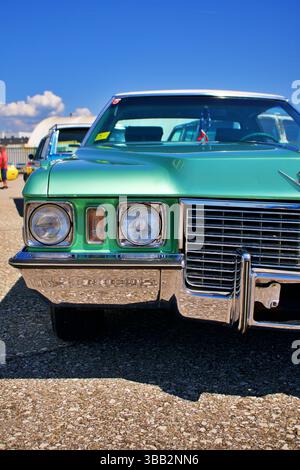 Primo piano anteriore della Classic Cadillac in verde menta con griglia cromata e fari esposti al salone dell'automobile Foto Stock
