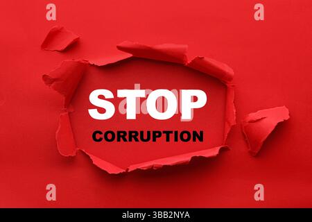 Parole Stop Corruption, vista attraverso il foro su carta rossa Foto Stock