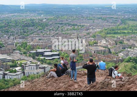 Arthur's Seat, Edimburgo, Scozia. I giovani ammirano la vista sulla città dal famoso monumento in un giorno di sole primaverili. Foto Stock