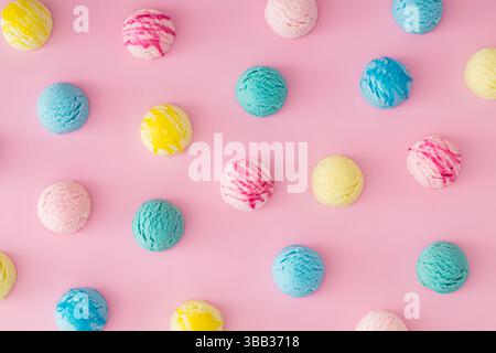 Composizione colorata composta da varie palline da gelato su sfondo rosa pastello. Concetto estivo minimalista. Un'idea di dessert dolce alla moda. Foto Stock