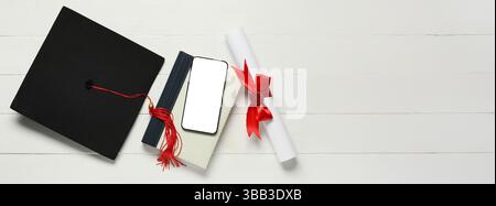 Cappello di graduazione, libro, telefono cellulare e diploma su sfondo bianco in legno con spazio per testo, vista dall'alto Foto Stock