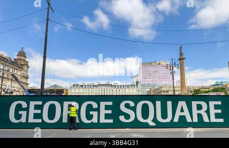 George Square, Glasgow, Regno Unito. 14 maggio 2025. Un lavoratore pulisce la grande segnaletica di George Square che circonda la riqualificazione da 20 milioni di sterline nella piazza simbolo del centro di Glasgow. Credito PIC: phil wilkinson/Alamy Live News Foto Stock