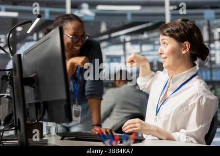 Il team leader di Happy Server Hub fa il primo passo con il lavoratore dopo aver completato le operazioni. Allegro manager che si congratula con l'ingegnere del data center dopo aver controllato il rapporto che mostra indicatori di prestazioni stabili Foto Stock