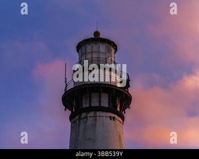 Half Moon Bay, CA - 12 26 2023: Vista ravvicinata della cima del faro di Pigeon Point contro un vibrante cielo al tramonto. Foto Stock