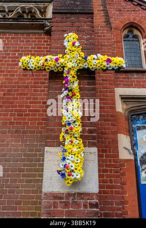 Croce cristiana decorata con fiori colorati per Pasqua all'esterno della chiesa di St Andrews lungo il viale di Southampton, Inghilterra, Regno Unito Foto Stock