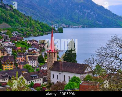 Bellissimo villaggio sul lago con una chiesa e montagne alpine in Svizzera durante la primavera Foto Stock