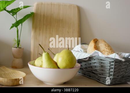 Pere fresche e pane disposti su un tavolo di legno Foto Stock