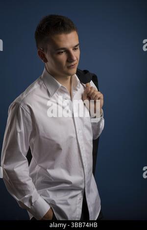Ritratto di un giovane uomo davanti a sfondo blu Foto Stock