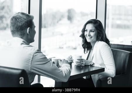 Coppia che si gode un caffè e parla in un bar Foto Stock