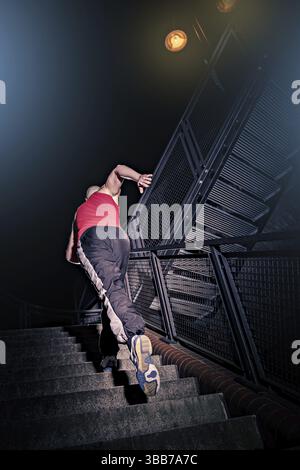 Un giovane alla formazione parkour in città Foto Stock