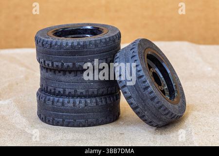 Pile di pneumatici per auto giocattolo con cerchioni neri, set di ruote, 3 pneumatici impilati, uno pneumatico appoggiato sugli altri Foto Stock
