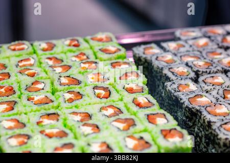 Su un vassoio ben disposto, ci sono molti tipi diversi e deliziosi di sushi che aspettano di essere gustati da coloro che apprezzano la cucina raffinata Foto Stock