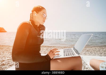 Laptop Woman Beach che lavora in remoto sulla spiaggia Foto Stock