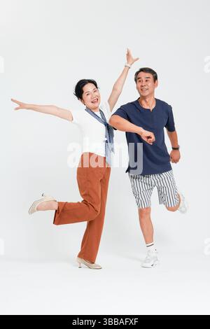 coppia anziana che salta con le braccia larghe open​ Foto Stock