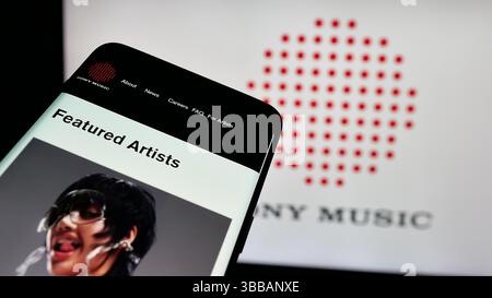 Stoccarda, Germania - 20-12-2024: Smartphone con sito Web della società statunitense Sony Music Entertainment (SME) sullo schermo davanti al logo aziendale. Foto Stock