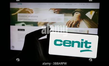 Stoccarda, Germania - 12-27-2024: Persona che detiene un telefono cellulare con sullo schermo il logo della società tedesca di tecnologie dell'informazione CENIT AG Foto Stock