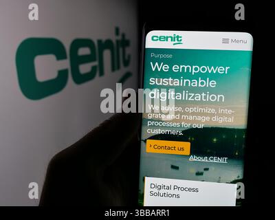 Stoccarda, Germania - 12-27-2024: Persona che detiene il cellulare con pagina web della società tedesca di tecnologie dell'informazione CENIT AG su schermo con logo. Foto Stock