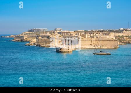 Fort Ricasoli Malta, vista sul Grand Harbour della Valletta verso il faro e la frana situata sul forte Ricasoli, Malta Foto Stock