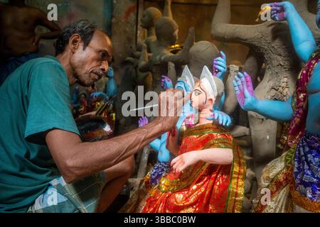 Un artigiano ha rifinito la statua della dea Durga, distretto di Kumartuli, in paglia e argilla durante il Durga Puja festival, Kolkata, Calcutta, Foto Stock
