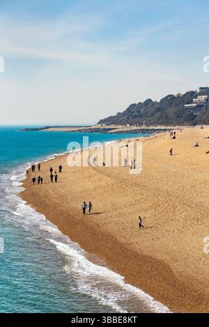 Persone che camminano lungo Folkestone Beach, Folkestone, Kent, Inghilterra Foto Stock